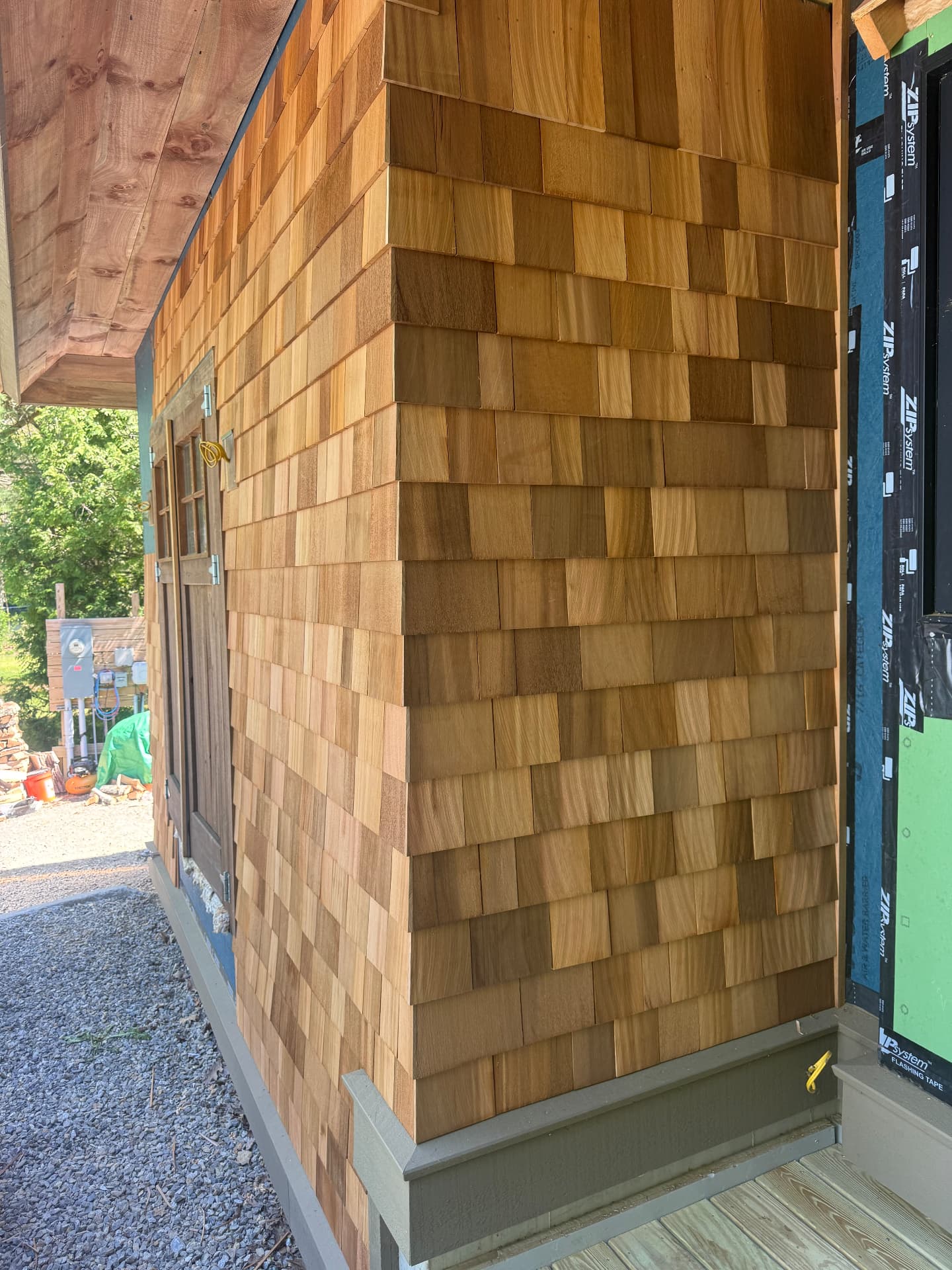 Close up of hand laid cedar shake siding with cedar soffit above