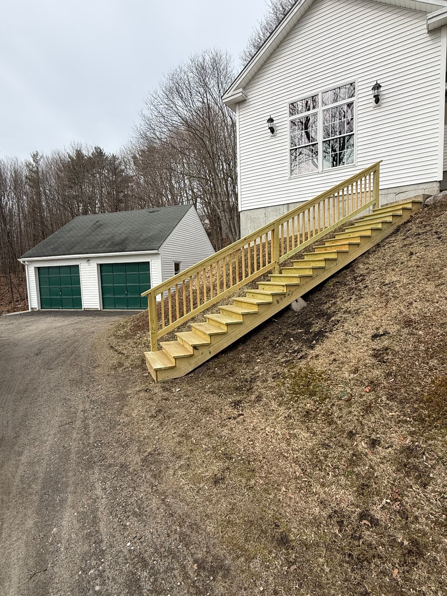 Long hillside stairway with railing leading to a home