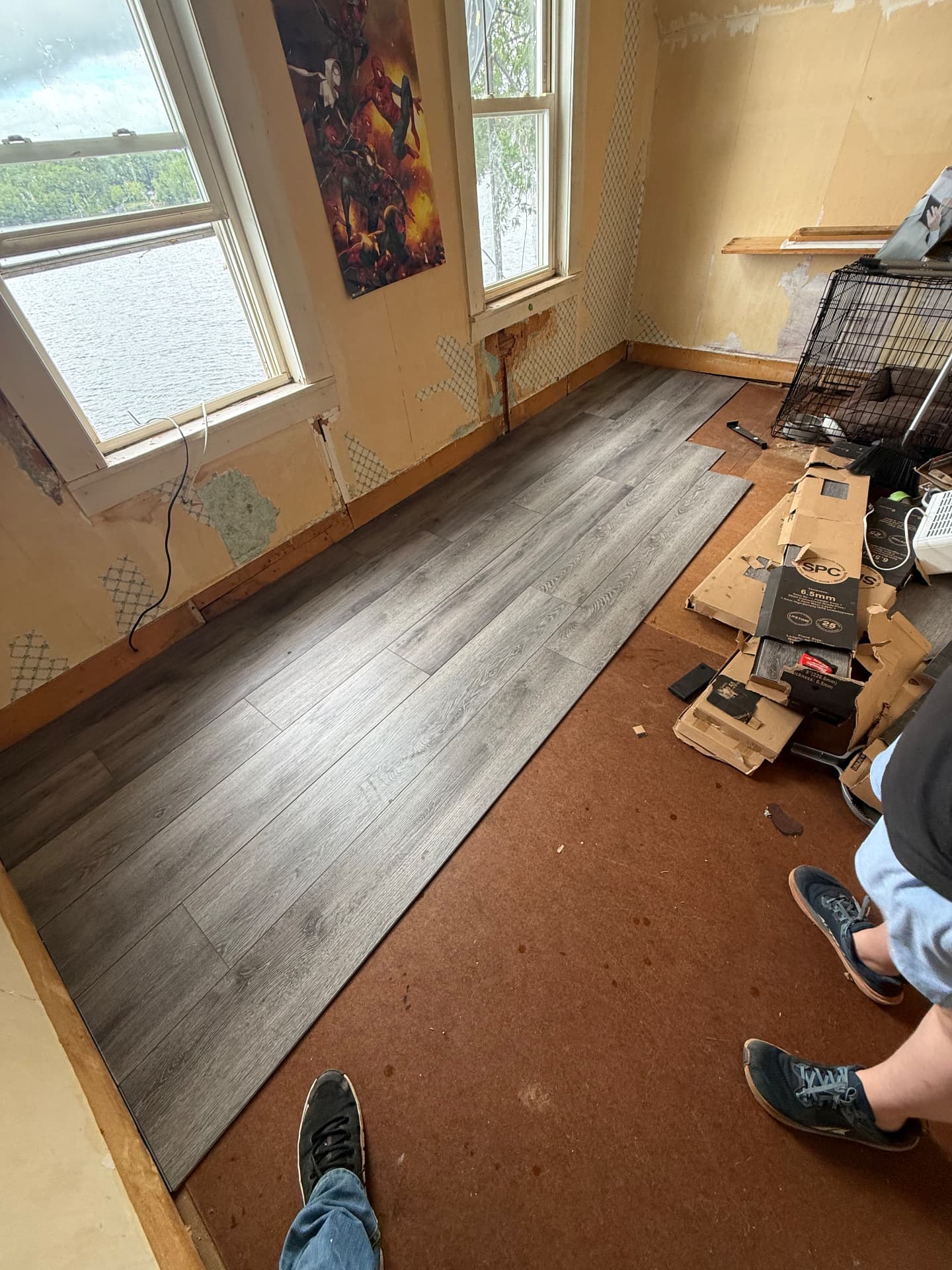 Luxury vinyl plank flooring being installed in a lakeside bedroom