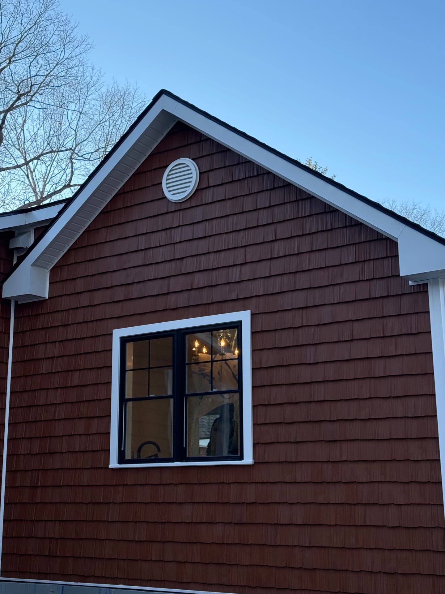 Cedar shake gable end with black windows and white trim detail