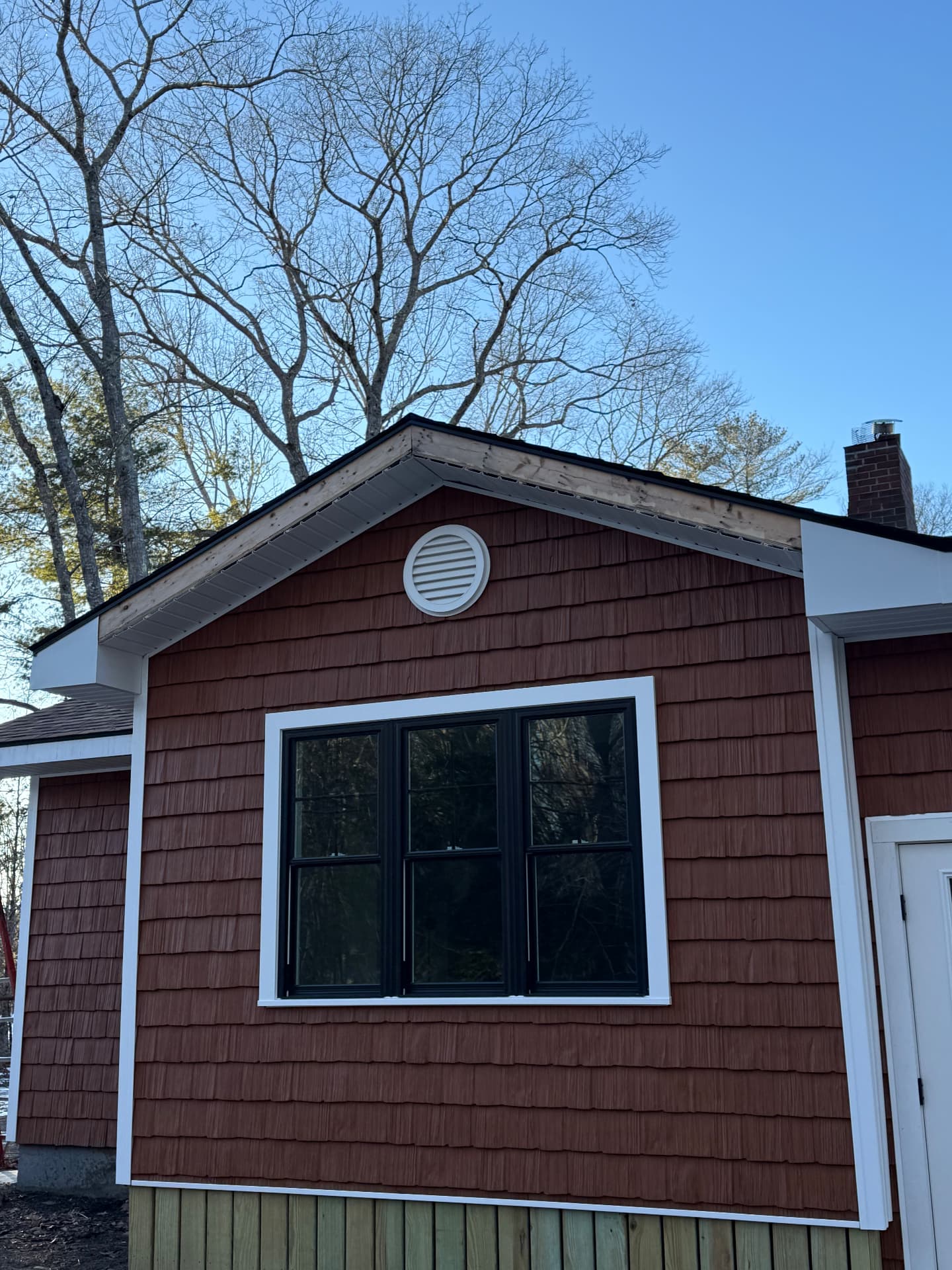 New shingle siding and trim on a gable end with a triple window