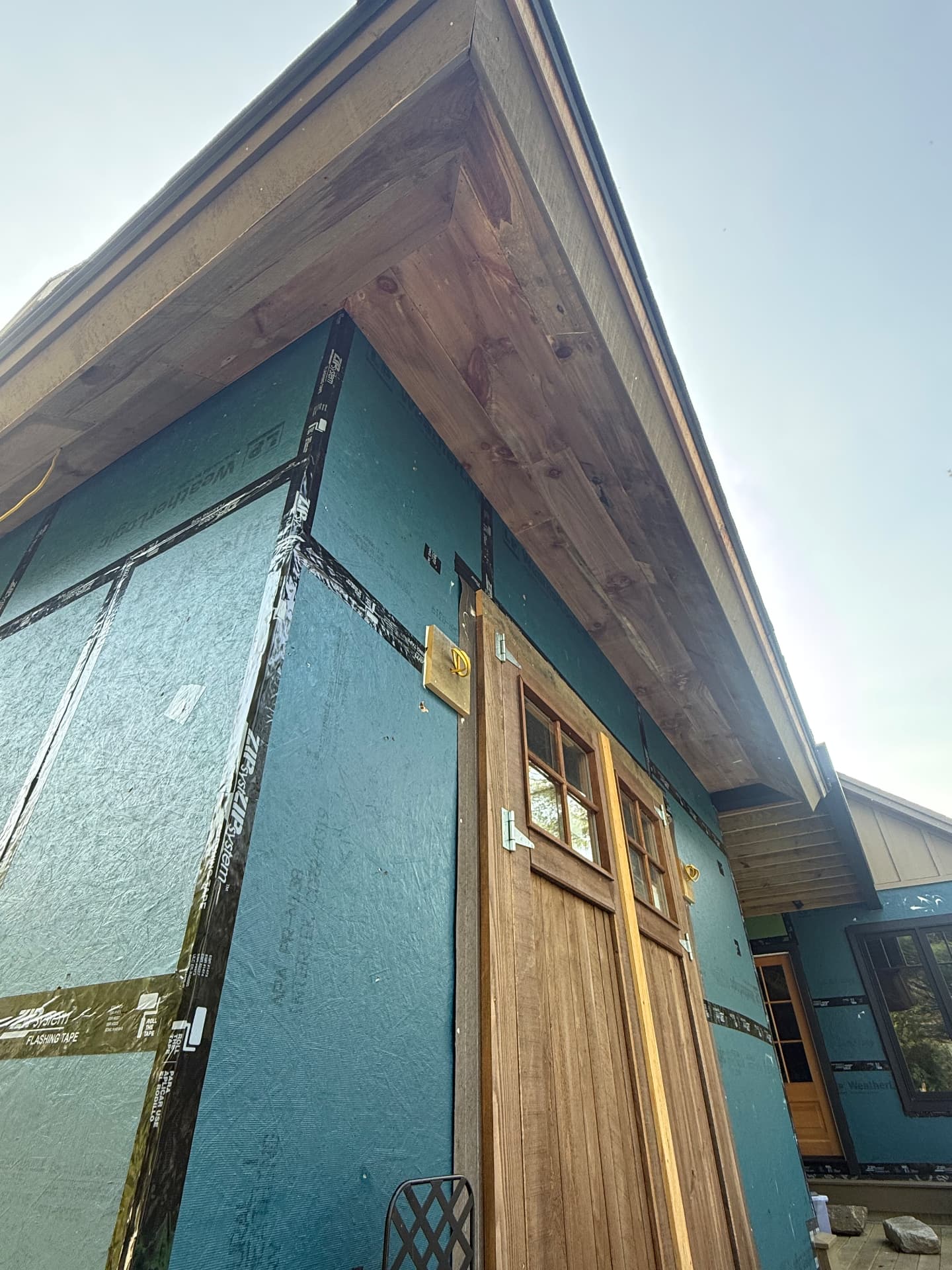 Timber framed eave and cedar soffit over a custom entry door